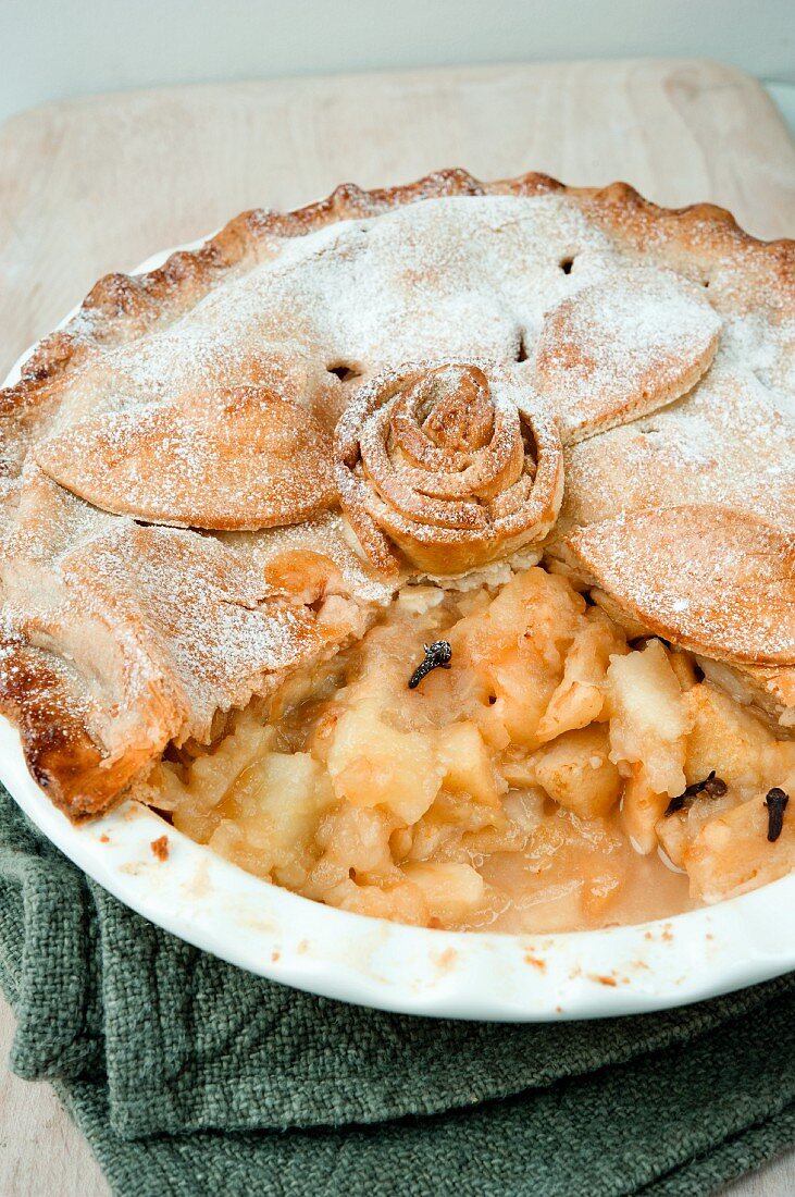 Apple pie with a pastry rose and powdered sugar