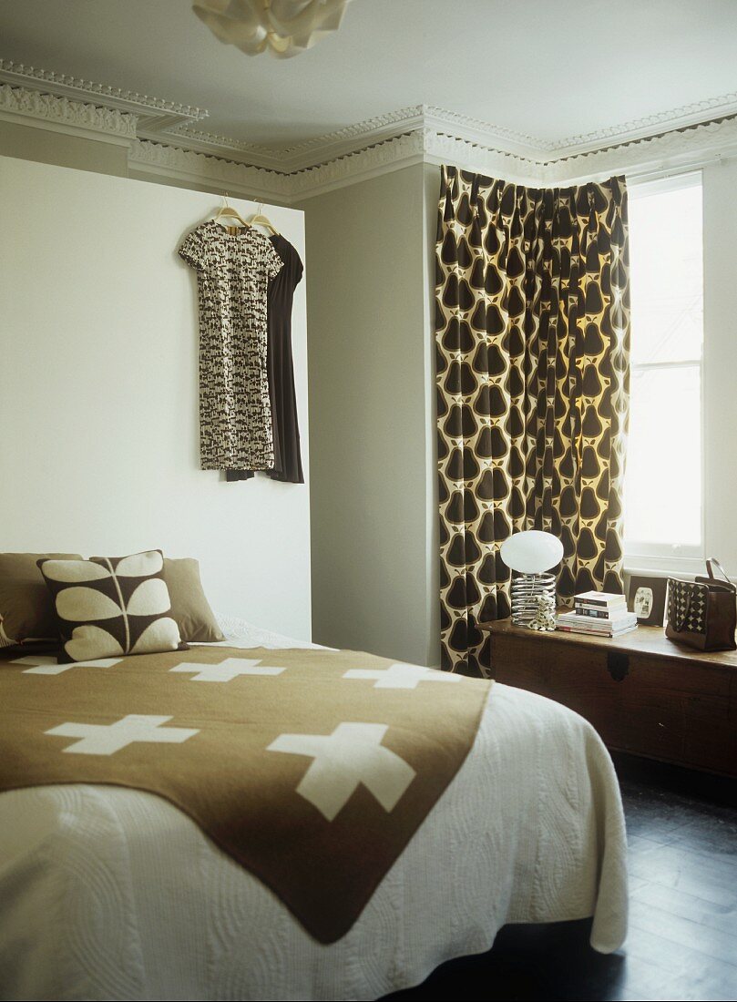 Plaid auf Doppelbett und Vorhang am Fenster in weiss brauner Farbgebung