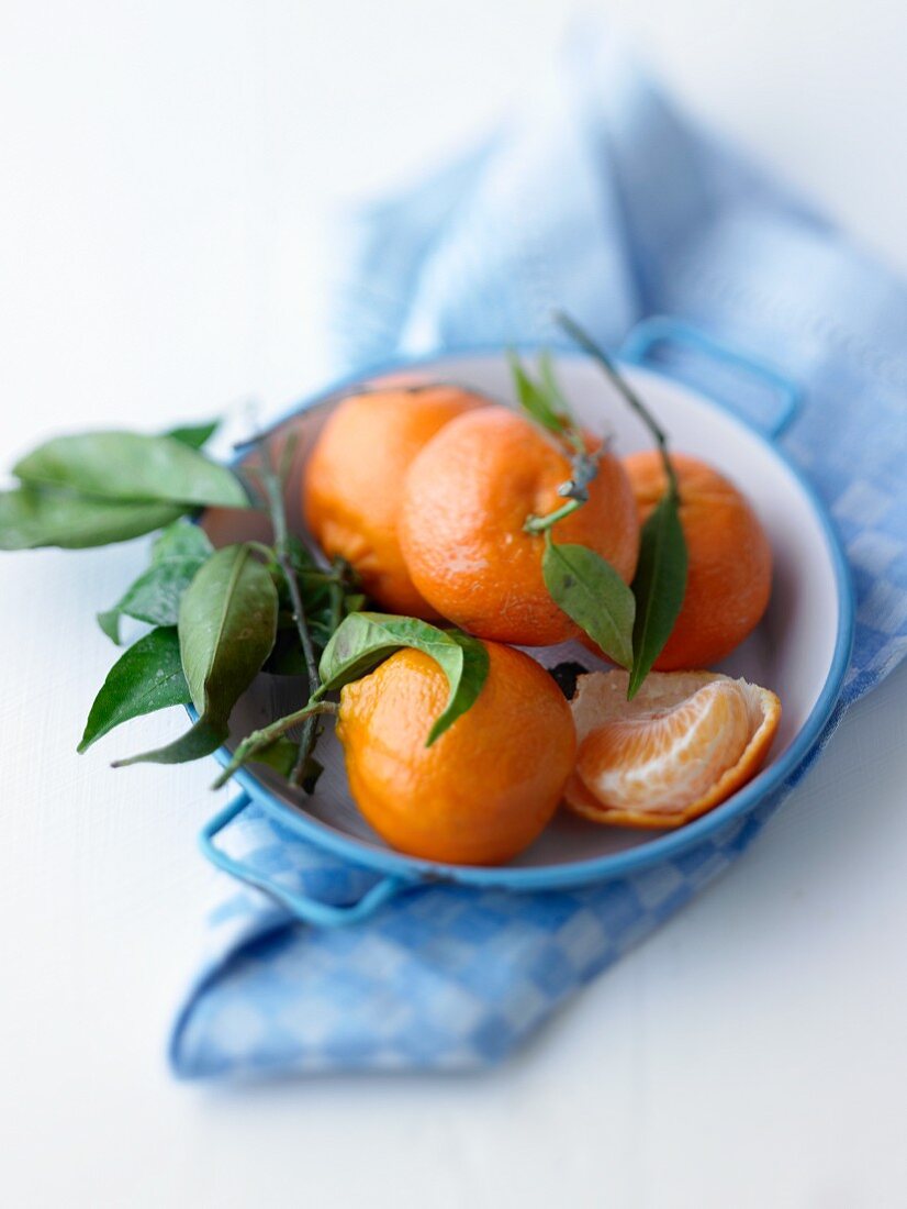 Tangerines with leaves in a bowl