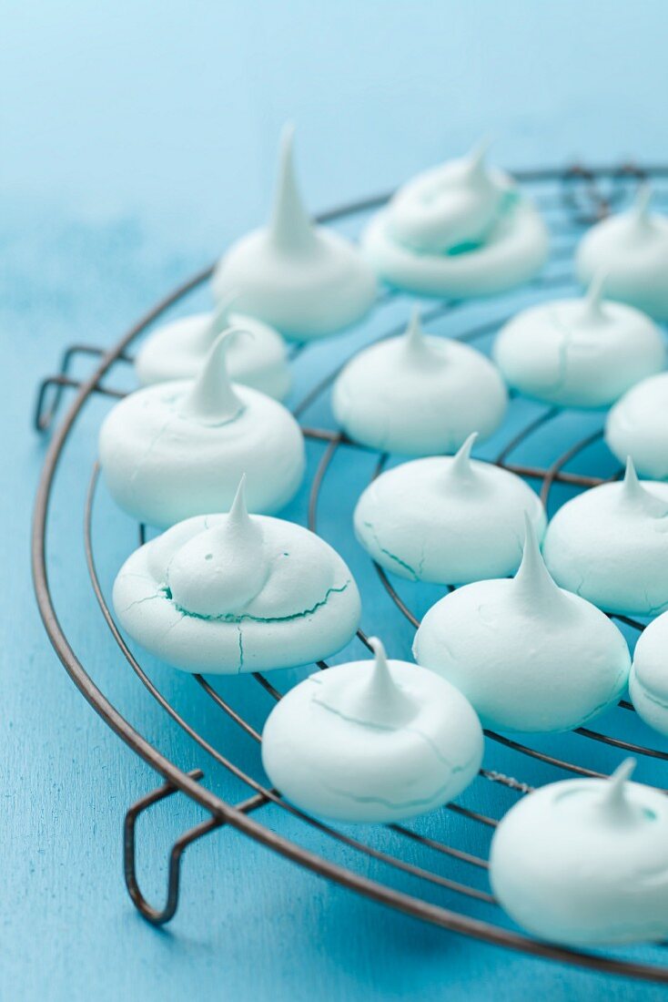 Turquoise meringues on a kitchen rack