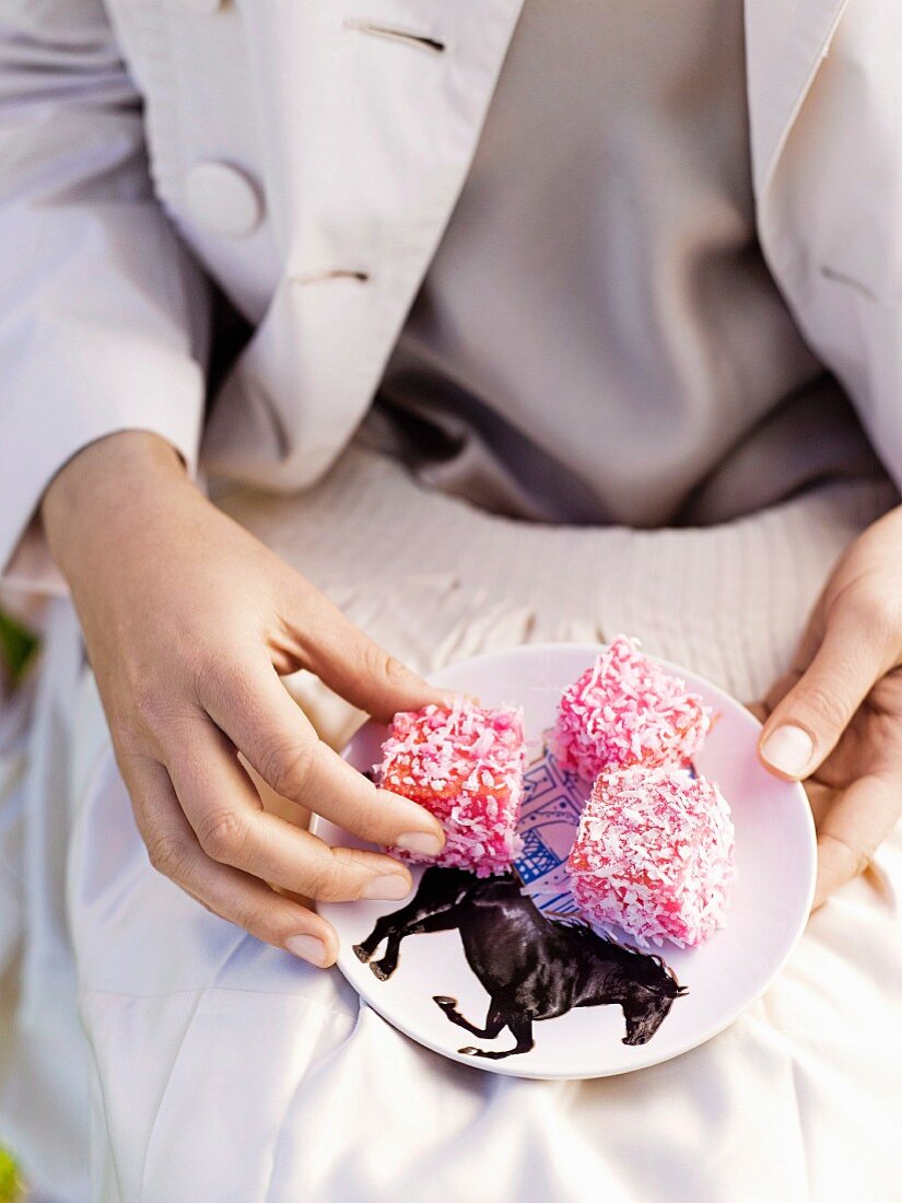 Woman holding a plate with lamingtons