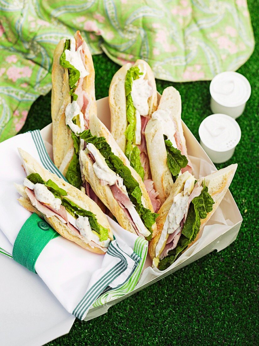 Mini-baguettes with ham, brie, lettuce leaves and mustard-mayo
