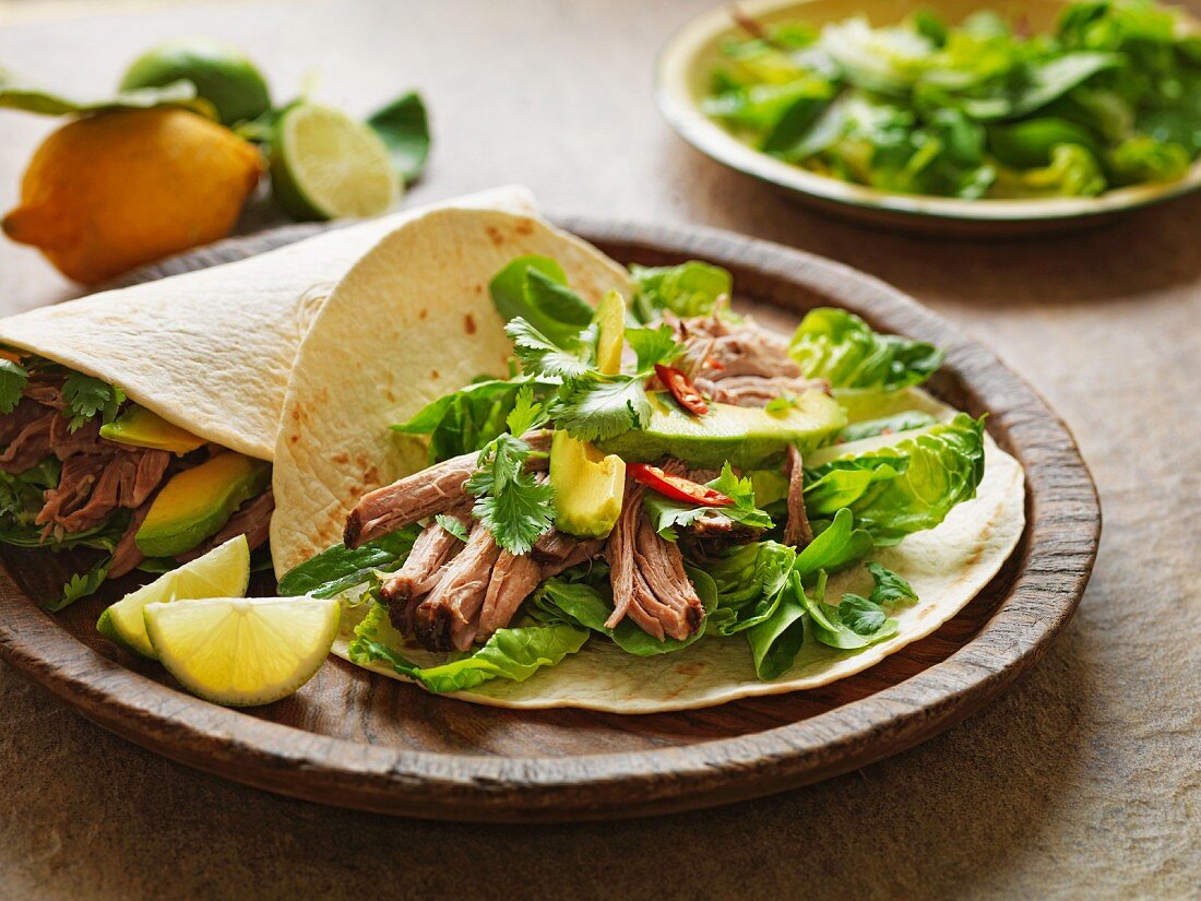Wrap with pork, lettuce leaves, avocado and chilli peppers