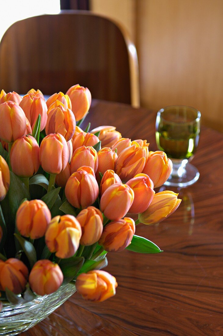 Orangefarbener Tulpenstrauss auf Tisch