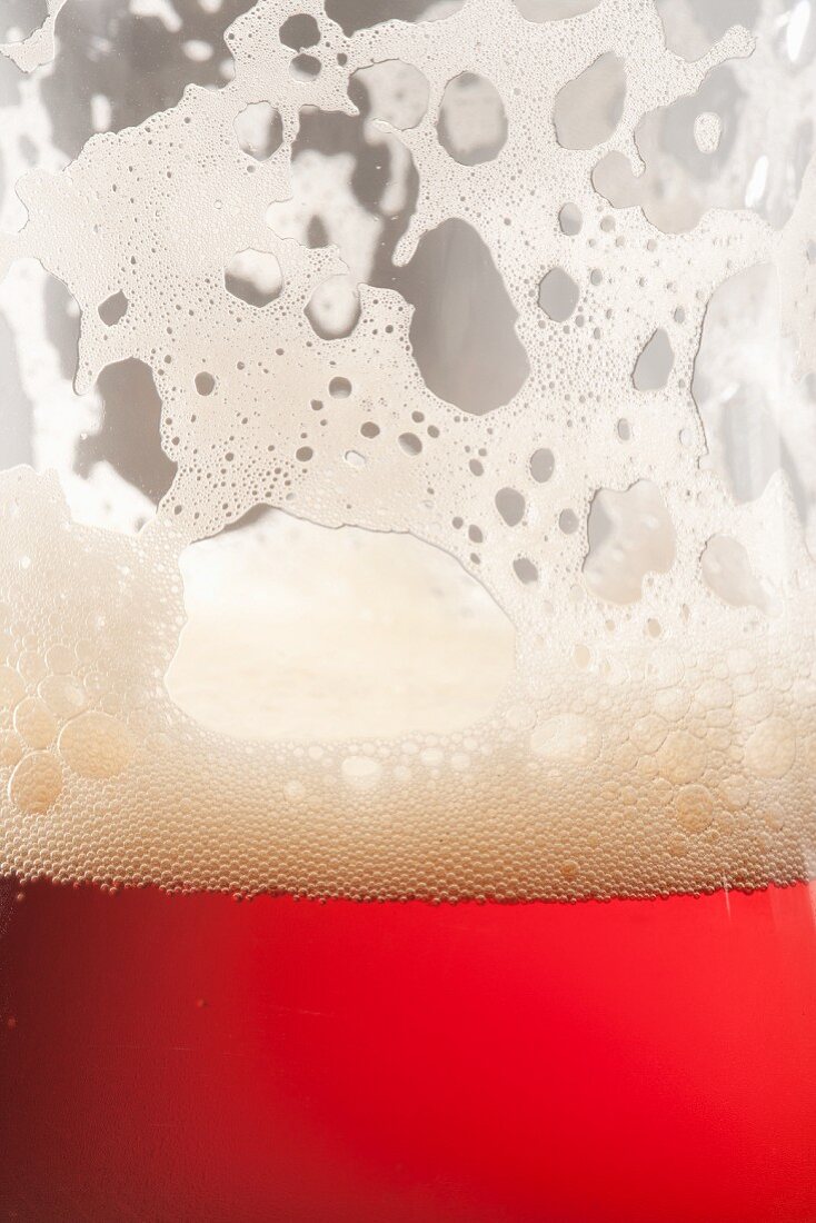 Glass of Amber Ale with Foam on Glass; Close Up