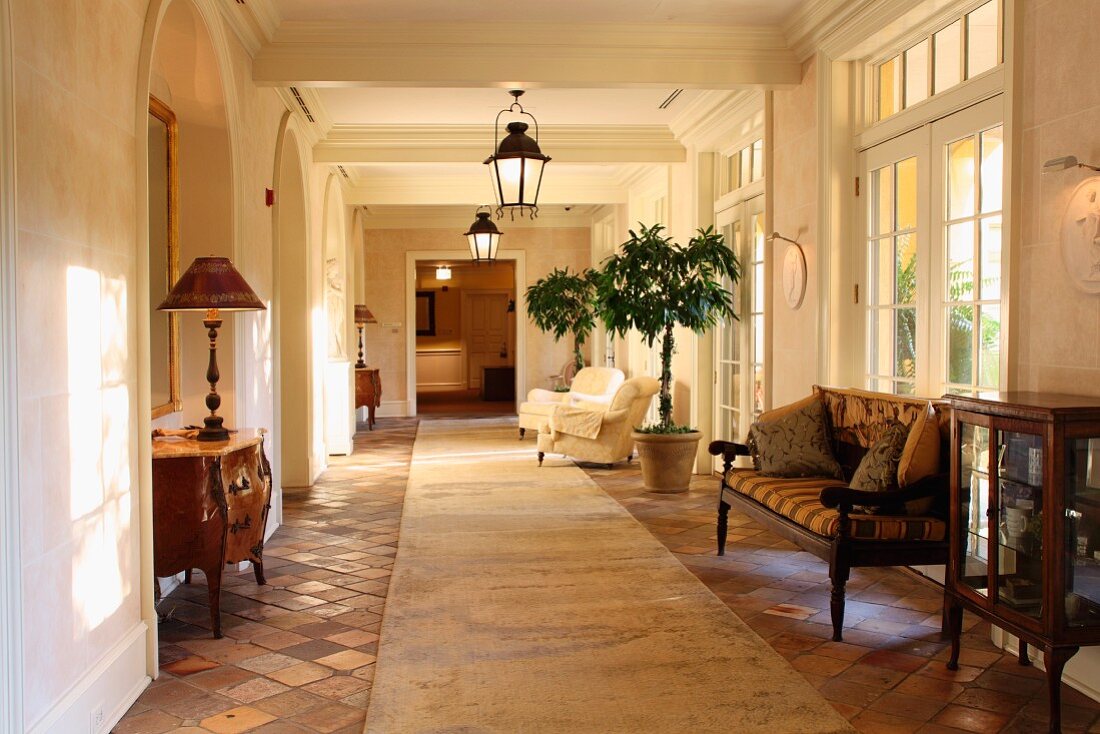 Antique furniture in spacious foyer with old terracotta floor in Mediterranean villa