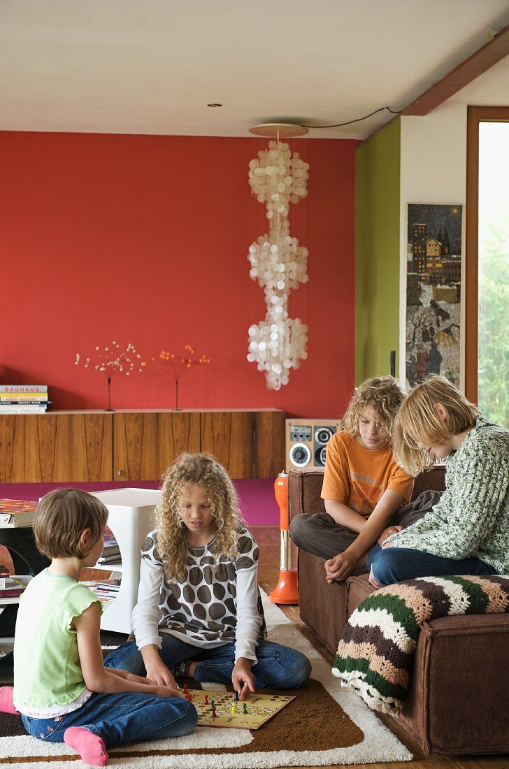 Spielende Kinder auf Teppich und Sofa im Wohnraum