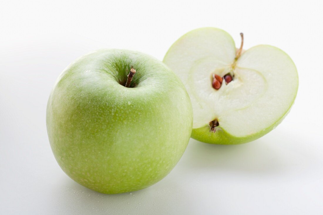 Whole apple and halved apple (variety: Granny Smith)