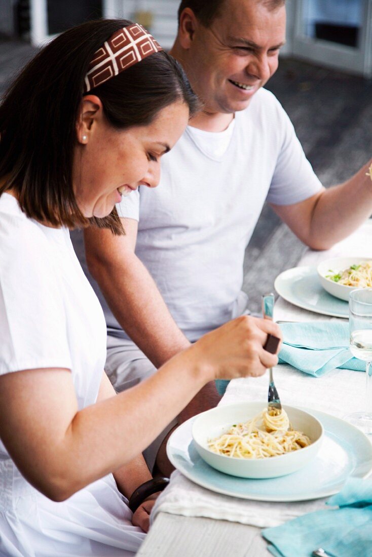 Two people eating spaghetti