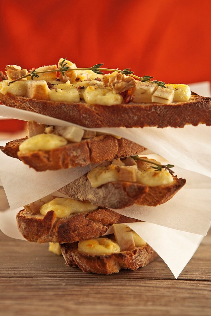 Stack of baguette slices with brie, pear & walnuts