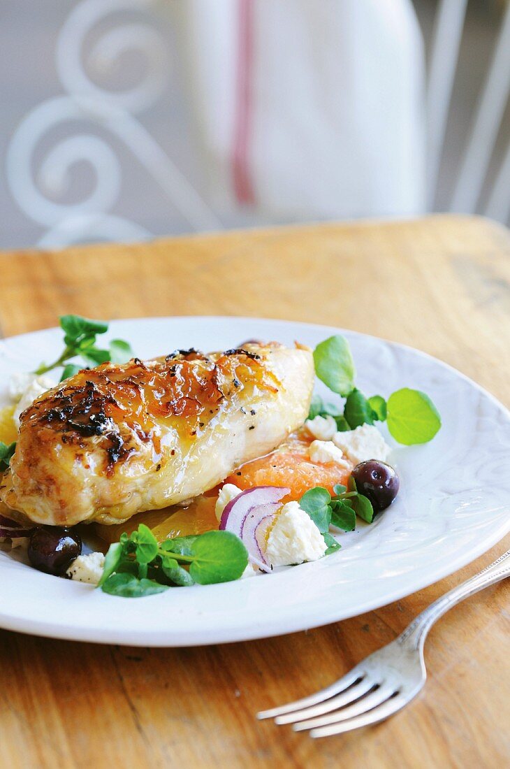 Chicken breast on citrus fruits with watercress, feta & olives