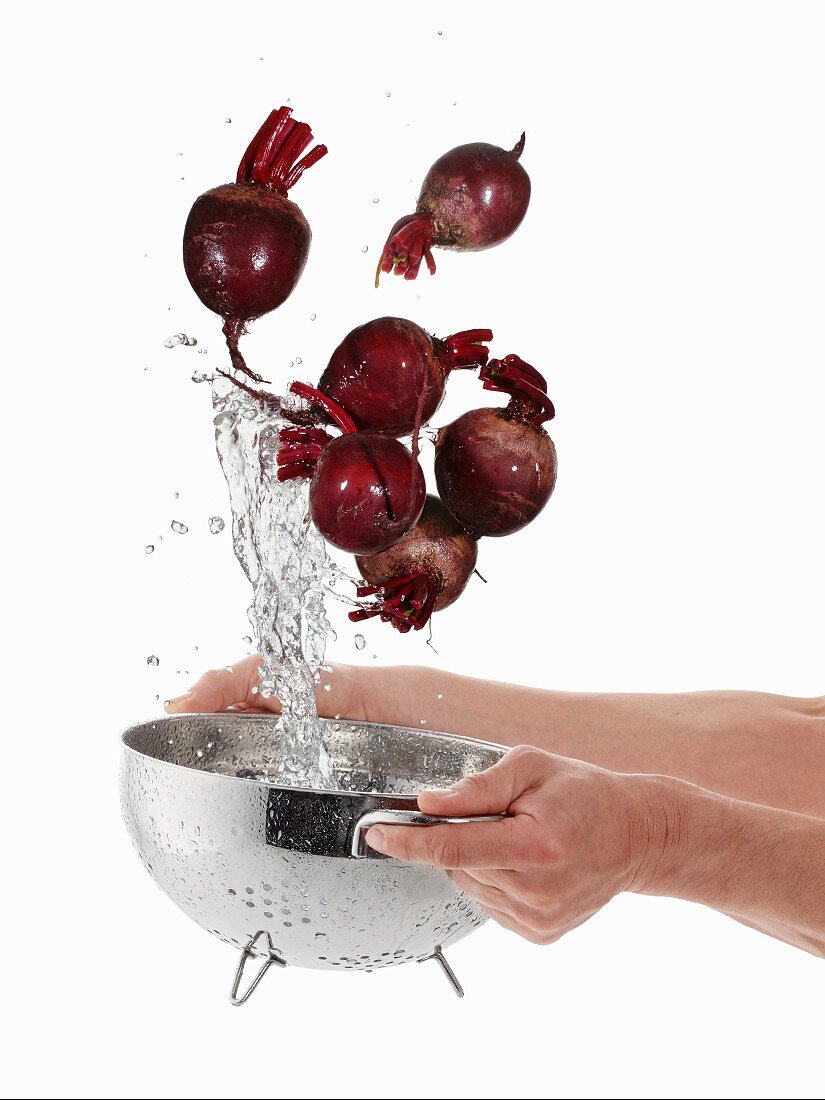 Washing beetroot in a sieve
