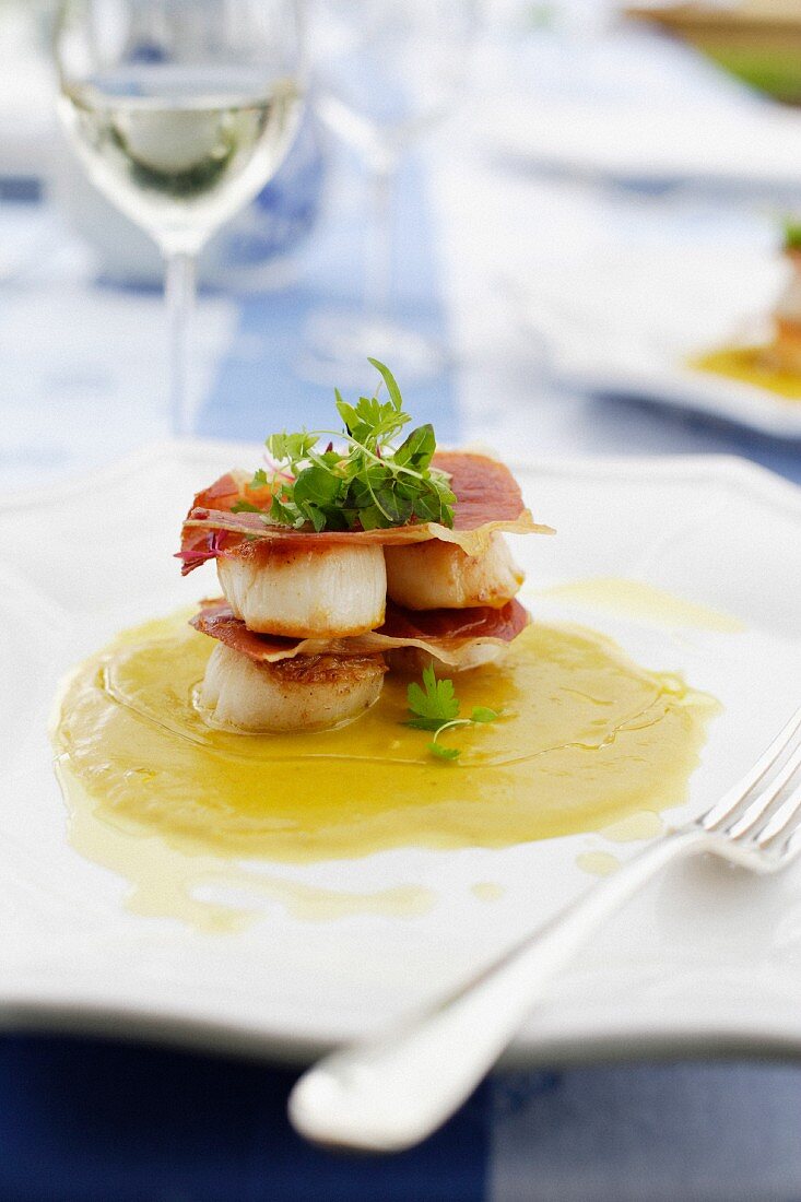 Layered dish of scallops and prosciutto with pumpkin and coconut sauce