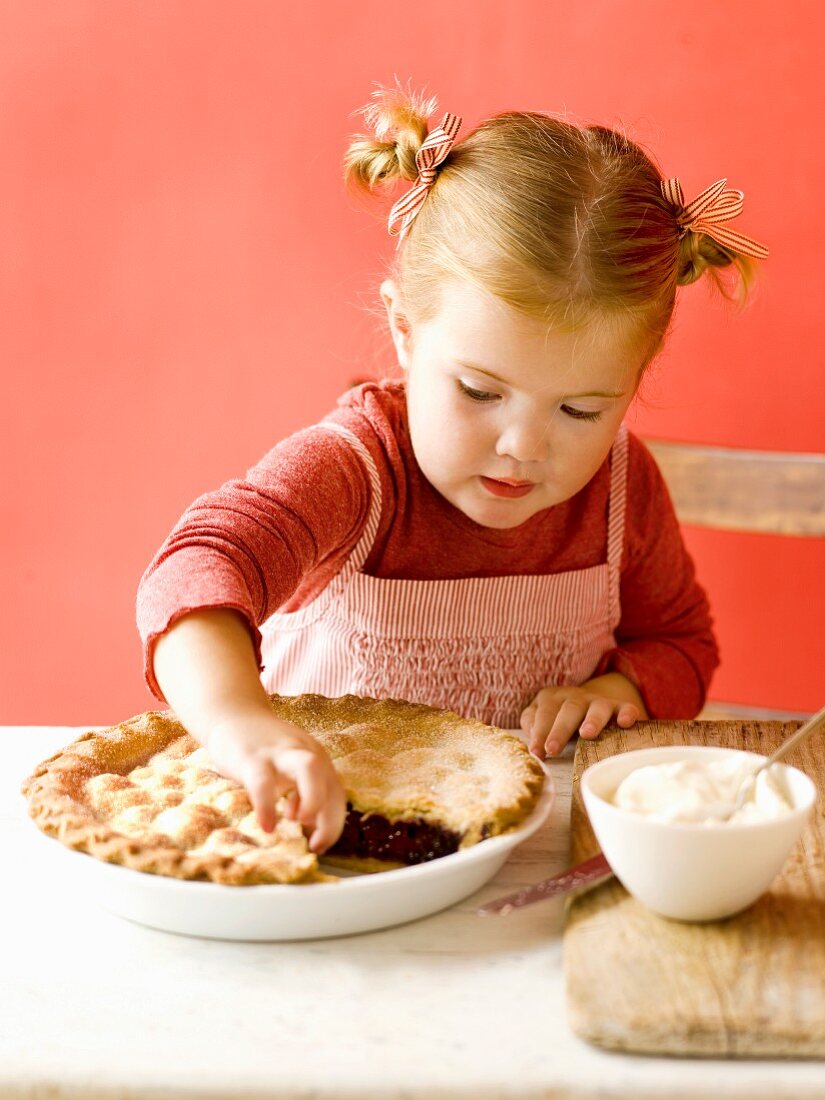 Kleines Mädchen nascht von einer Pie