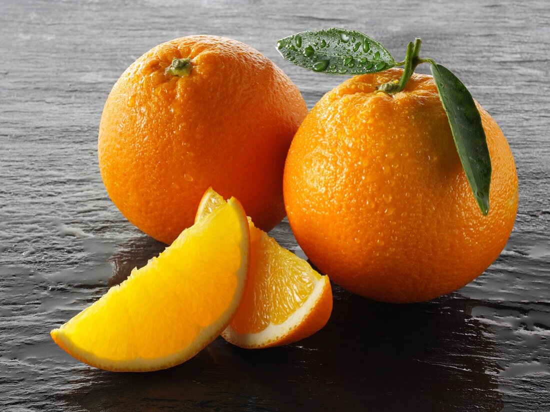 Two whole oranges and two oranges wedges