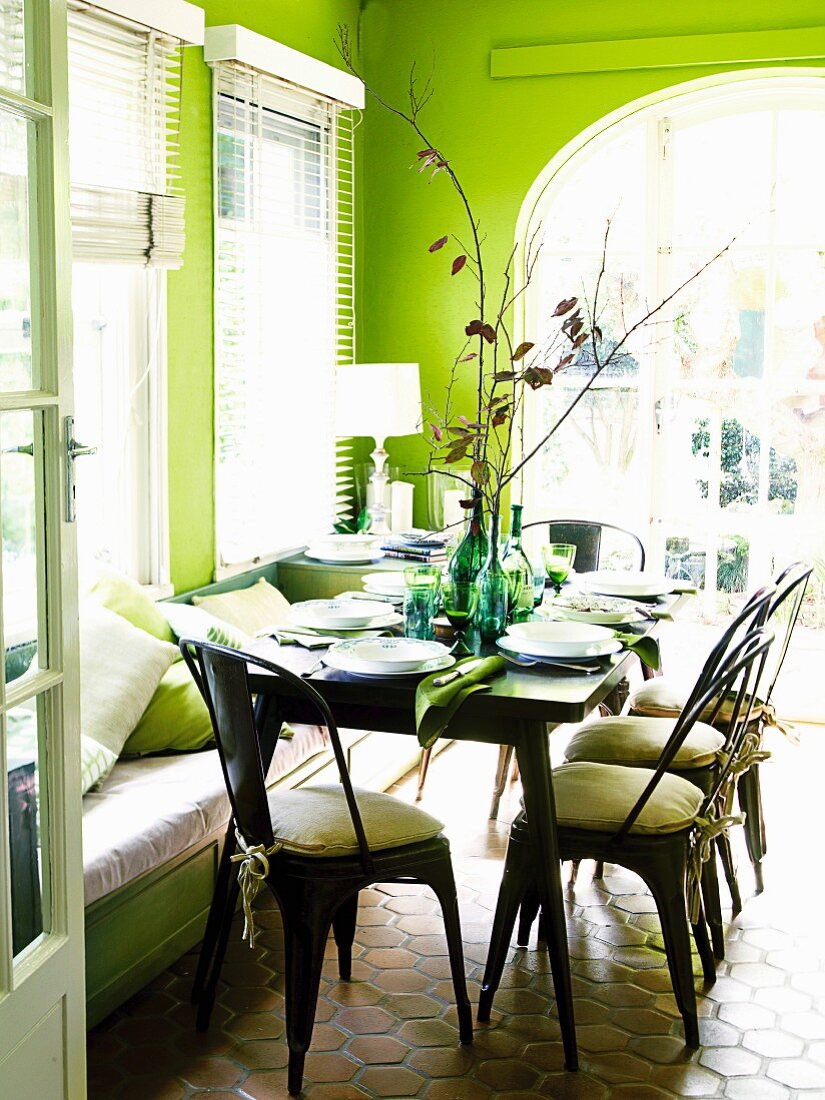 Gedeckter Tisch in grün gestrichenem Wohnraum