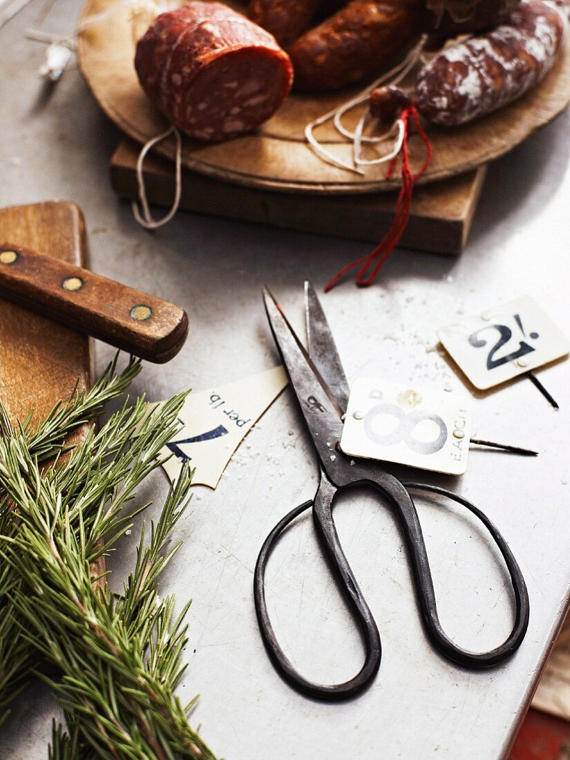 Various types of sausages, a pair of herb scissors and signs with numbers