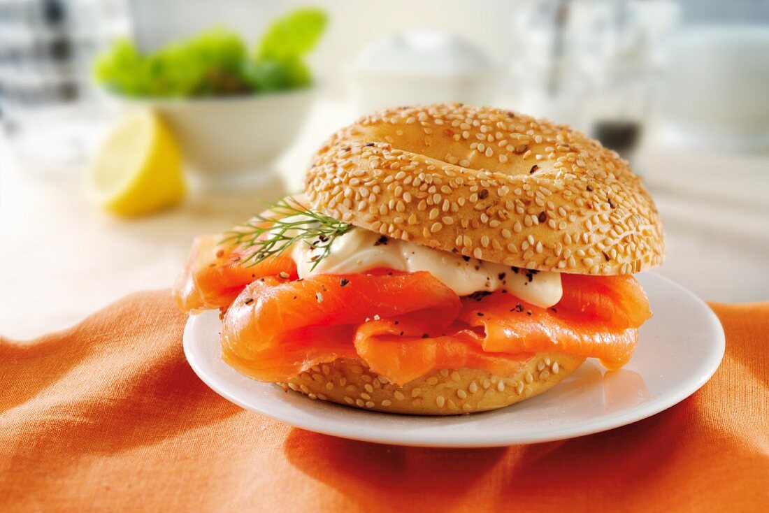 A sesame bagel with smoked salmon and mayonnaise