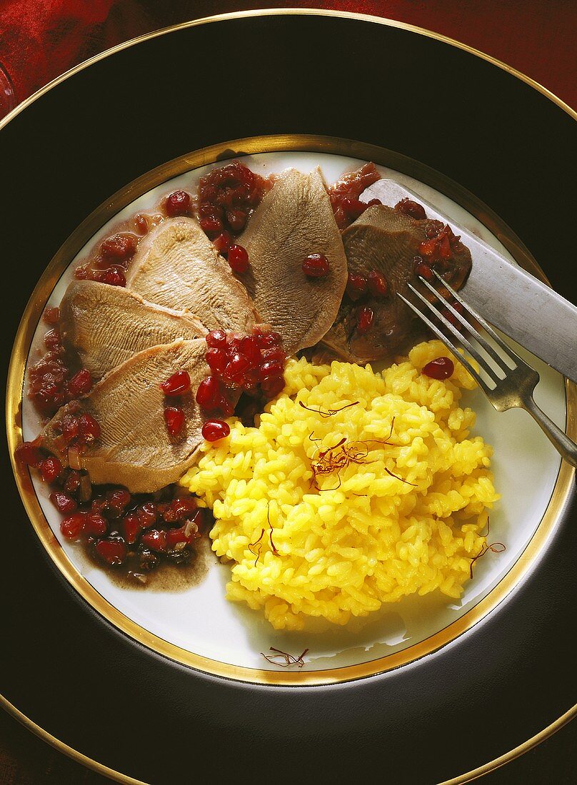 Tongues with pomegranate & saffron rice served on plates