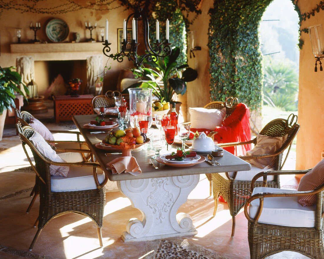 A hammock hangs across the loggia with oak chairs and a table made from old wine barrels, the latter laid for lunch