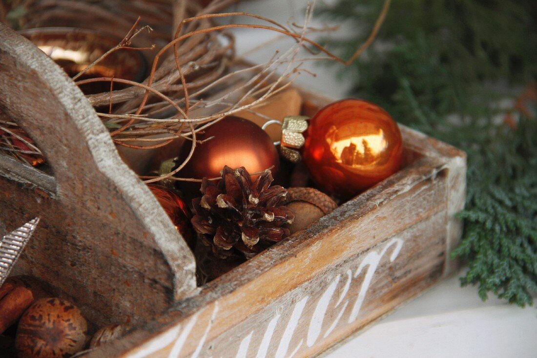 Wooden crate with pine cones and Christmas tree baubles