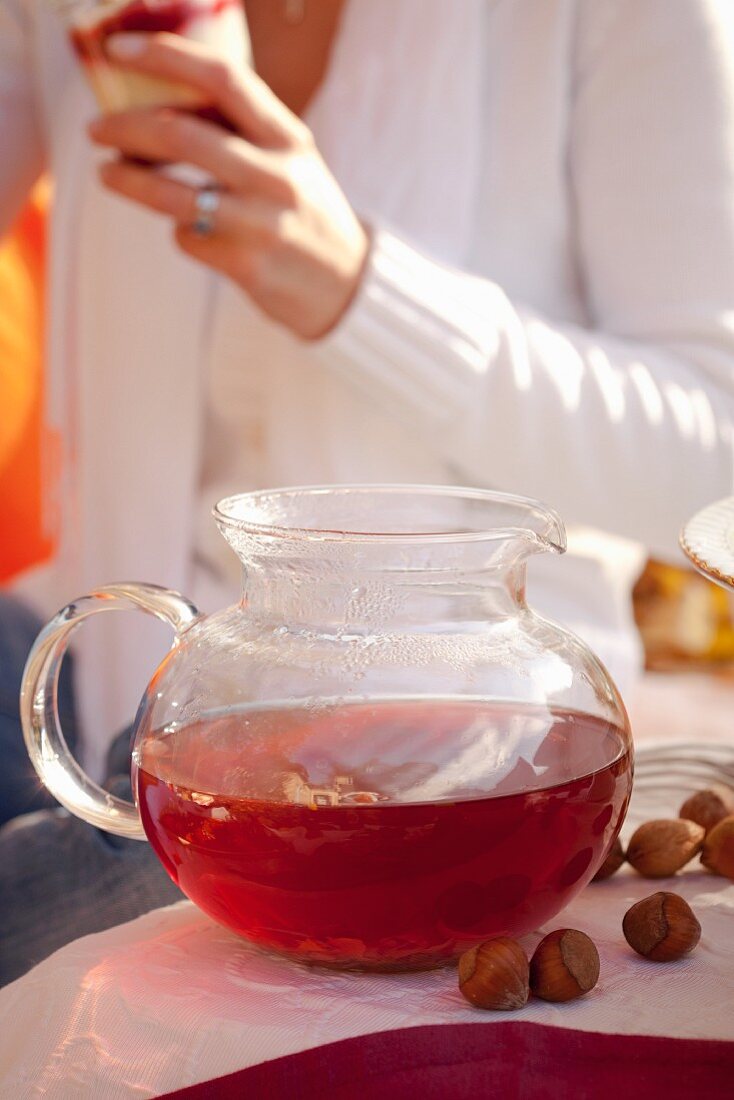 Woman with fruit tea at autumn picnic