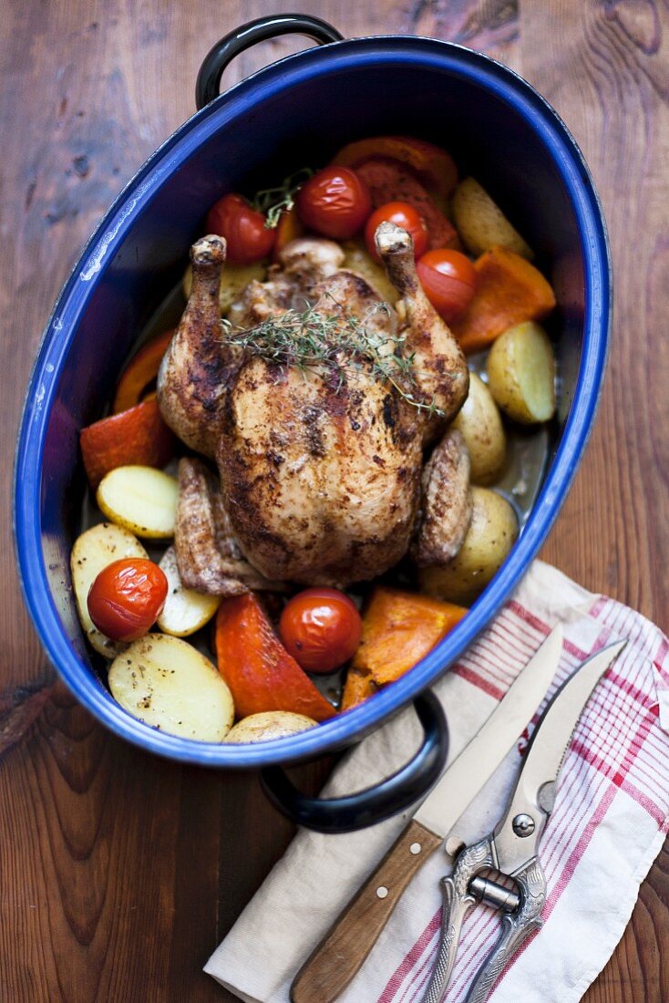 Chicken with pumpkin, potatoes and tomatoes in roasting dish