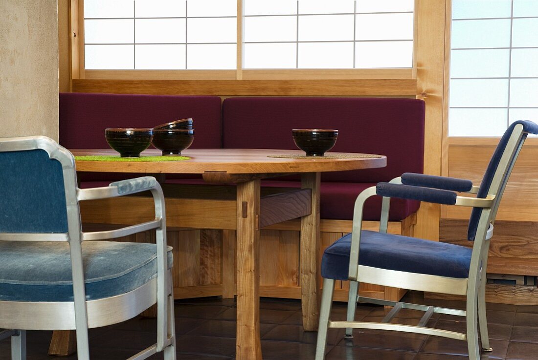 Teeschalen auf Esstisch aus Holz und gepolsterte Stühle mit Metallgestell