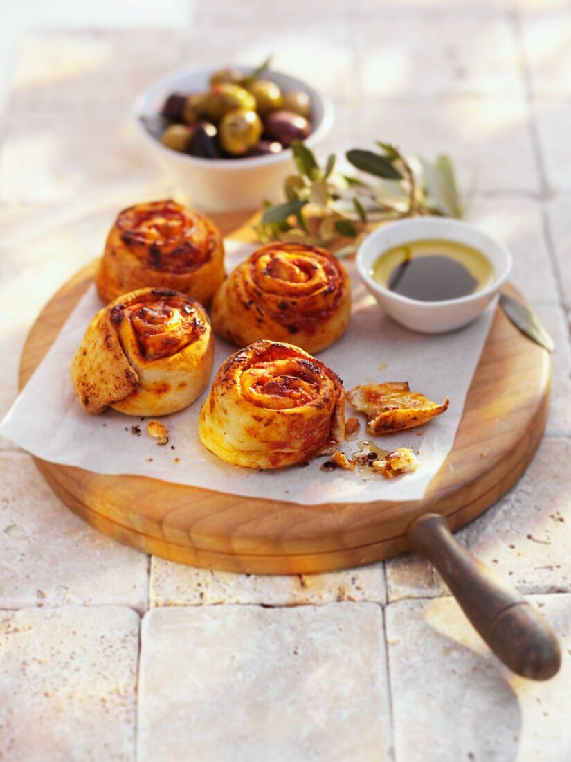 Cheese and tomato pastries, olive oil dip and olives
