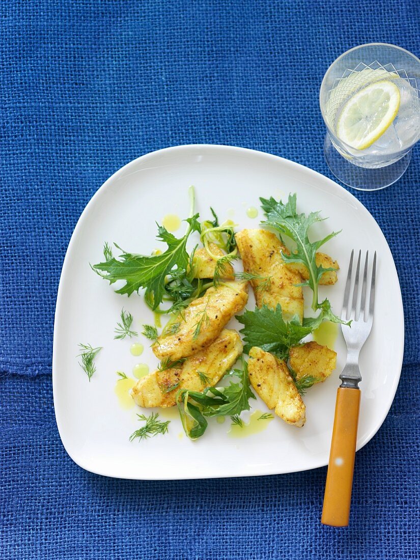 Cajun Style Cod with Greens on a White Plate; Fork