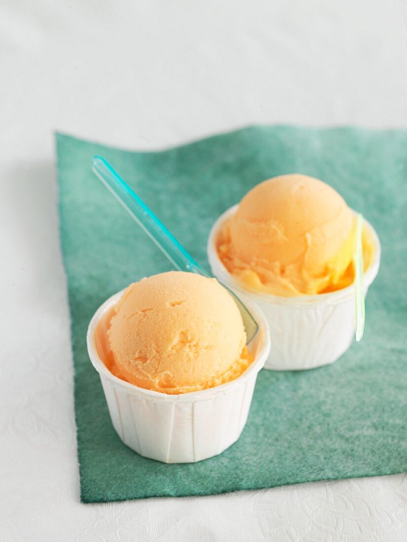 Zwei Eisbecher mit Orangensorbet