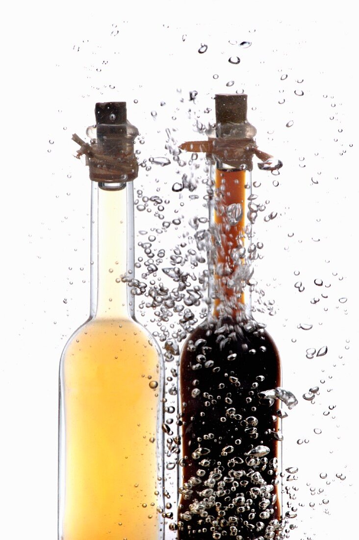 Vinegar and oil bottles in water with air bubbles