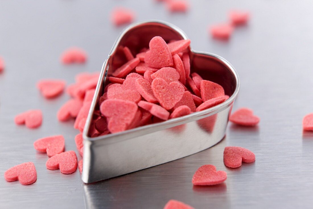 Heart-shaped cookie cutter and sugar hearts