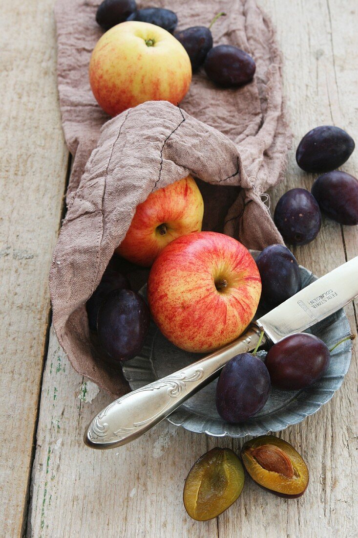 Apple and plums on a jute sack