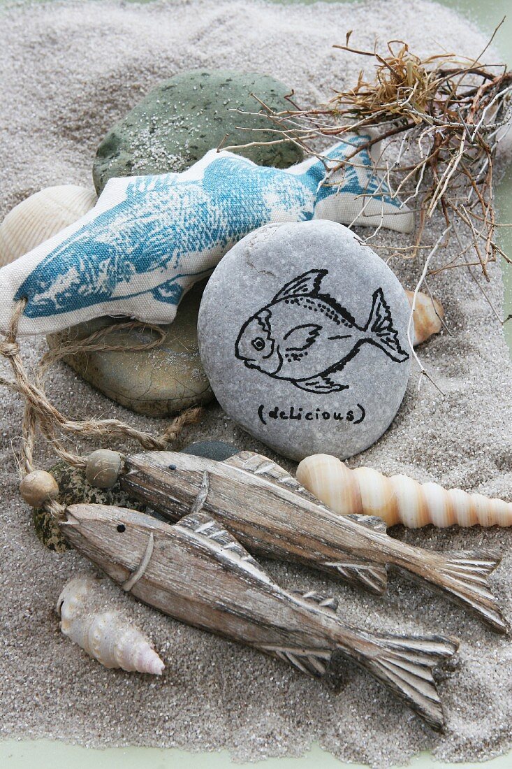 Fish ornaments and shells on a sandy beach