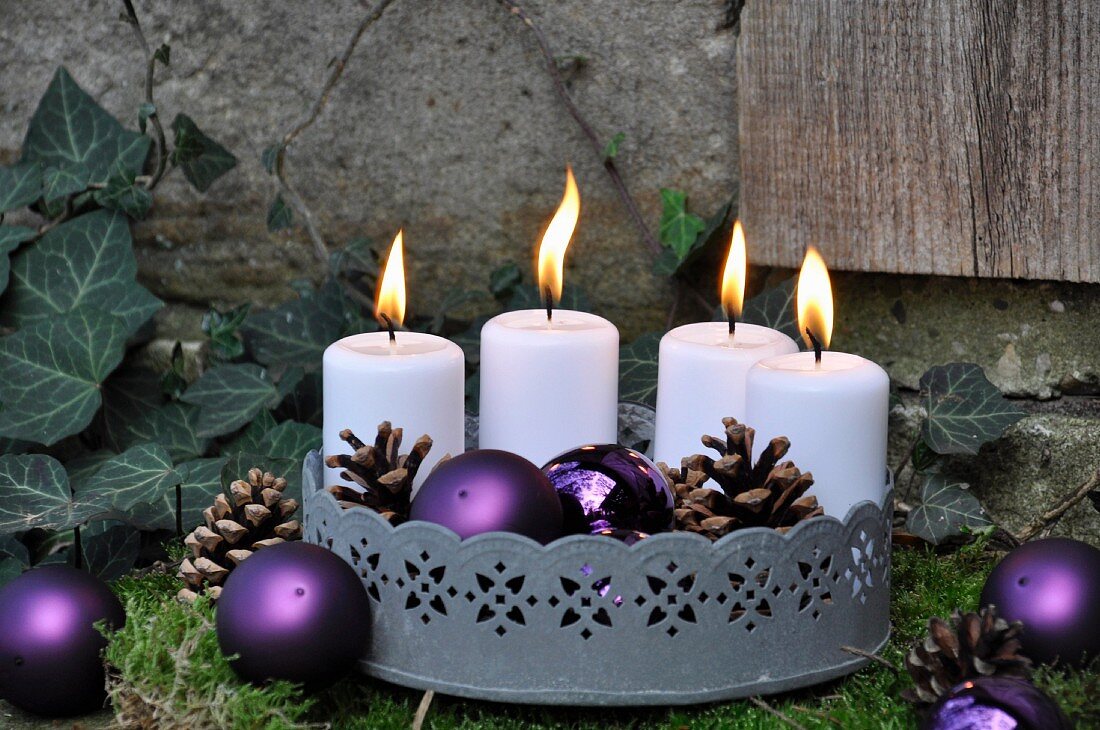 Festive garden decoration: zinc tray with candles on bed of moss
