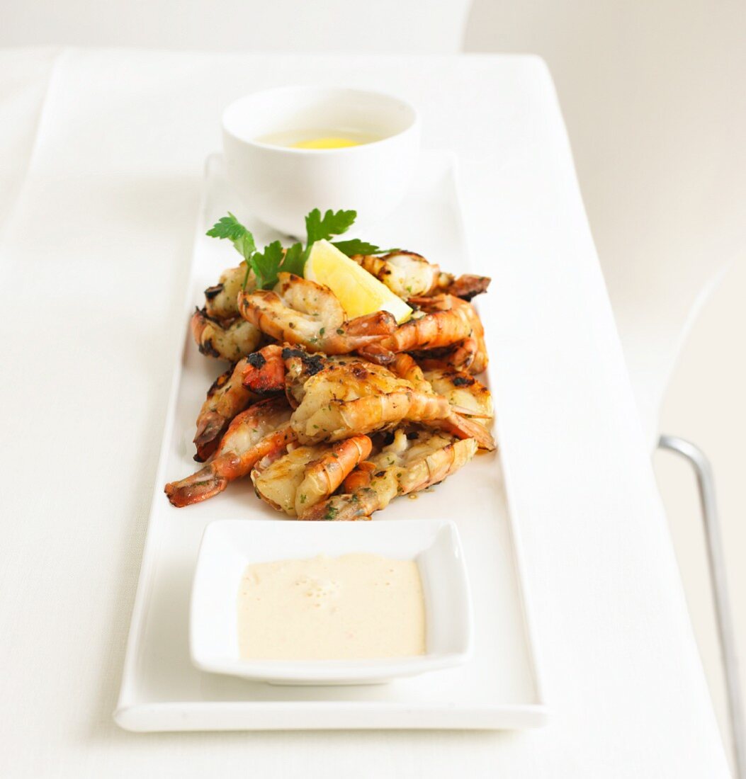 Grilled tiger prawns with sauce and lemons