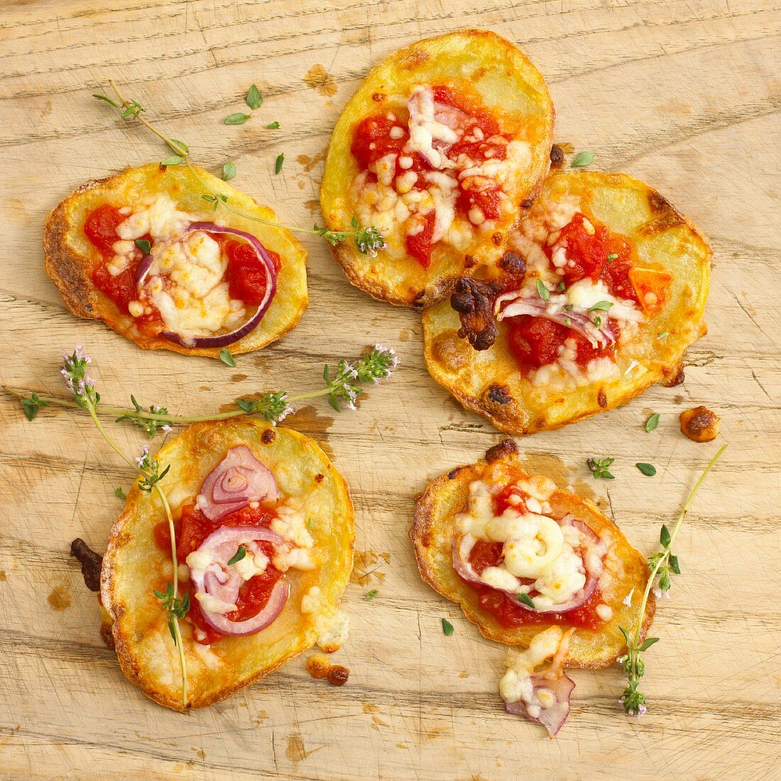 Knusprige Kartoffelscheiben mit Tomaten, Zwiebeln und Käse