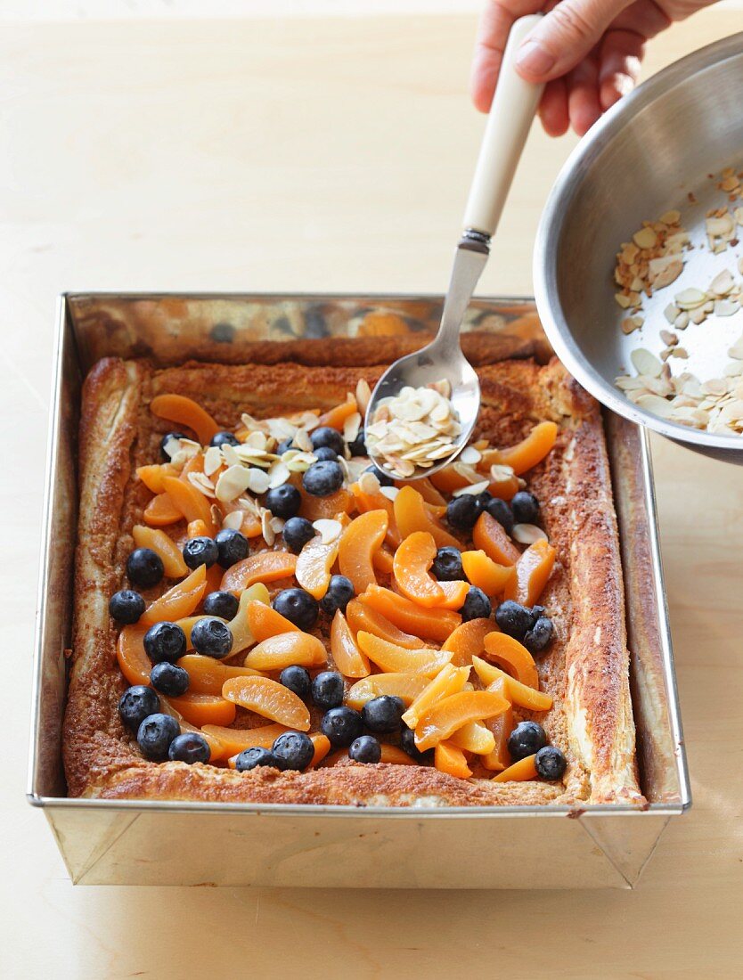 Obstkuchen mit Mandelblättchen bestreuen