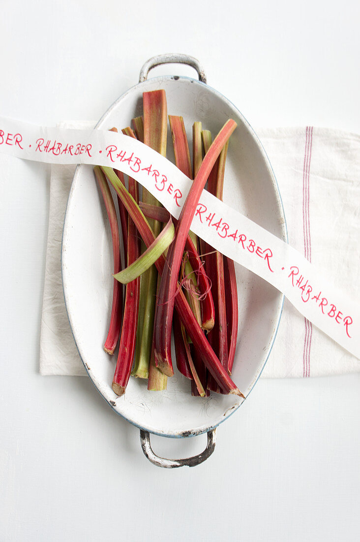 Rhubarb stems and ribbon with writing in a casserole dish