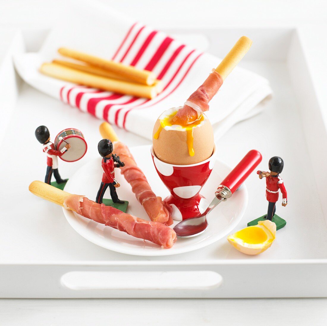 Grissini with ham, a soft boiled egg and toy figures