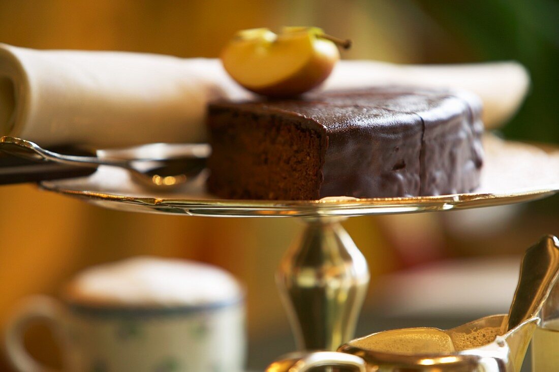 Slices of chocolate cake on a silver cake stand