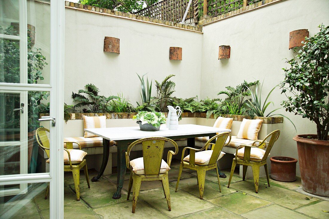 Metal furniture with peeling paint around antique table on terrace