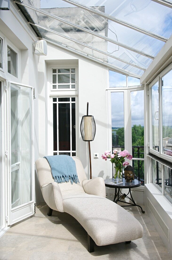 Art Deco-style chaise longue with white upholstery in conservatory