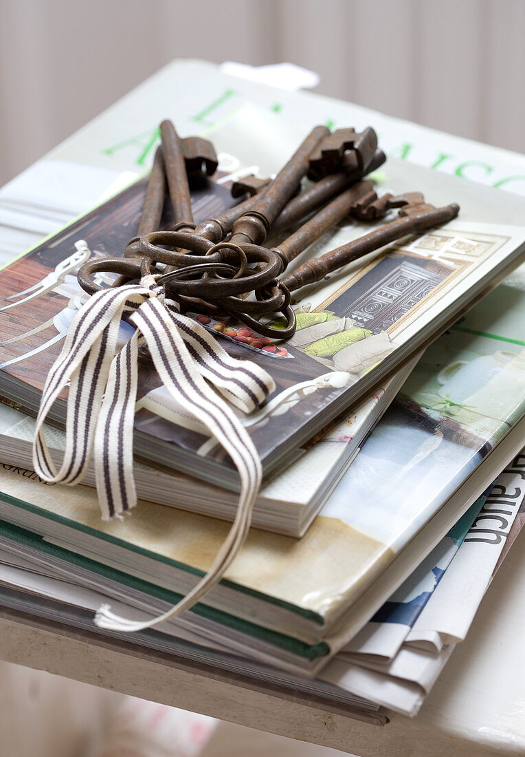 Bunch of vintage keys on stacked magazines