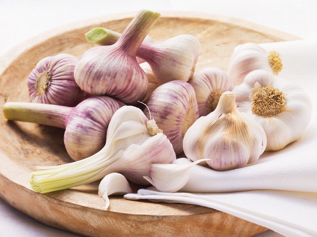 Garlic bulbs on a wooden plate