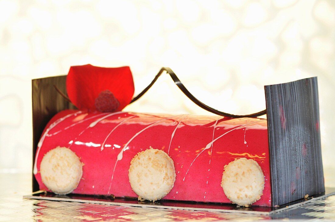 Raspberry roulade decorated with macaroons