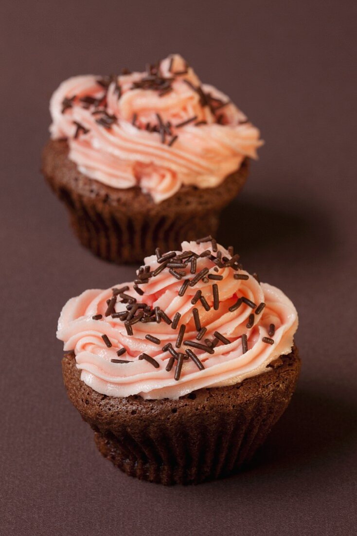 Chocolate cupcakes with strawberry cream and chocolate sprinkles