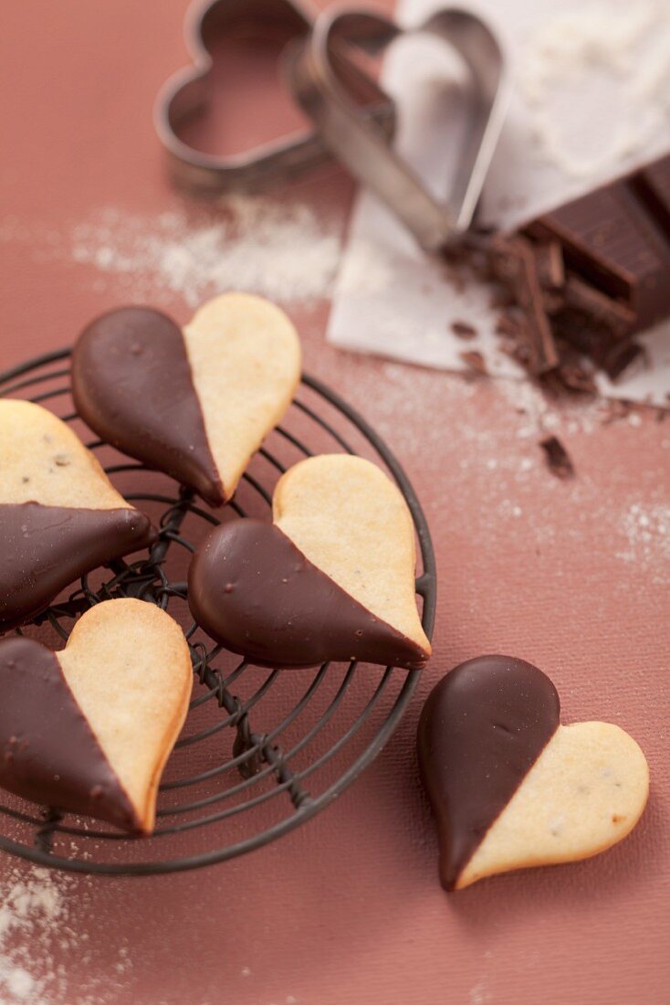 Heart-shaped biscuits with chocolate icing on a wire rack