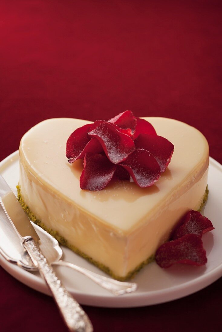 A heart-shaped cake decorated with rose petals for Valentines Day